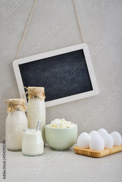 Fototapeta Various dairy products and eggs with framed chalk board