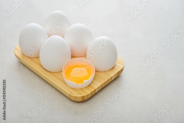 Fototapeta Eggs with white shell in wooden egg holder