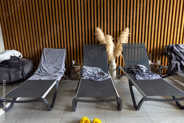 Fototapeta Sunbeds without people, with towels scattered around.