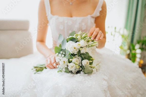 Fototapeta bride holding bouquet of flowers in her lap