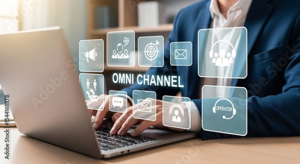 Fototapeta Man typing on laptop with omni channel icons displayed above the keyboard in a bright setting