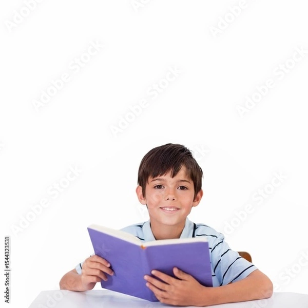 Obraz School-age boy is reading blue book at white table in flat design on white background