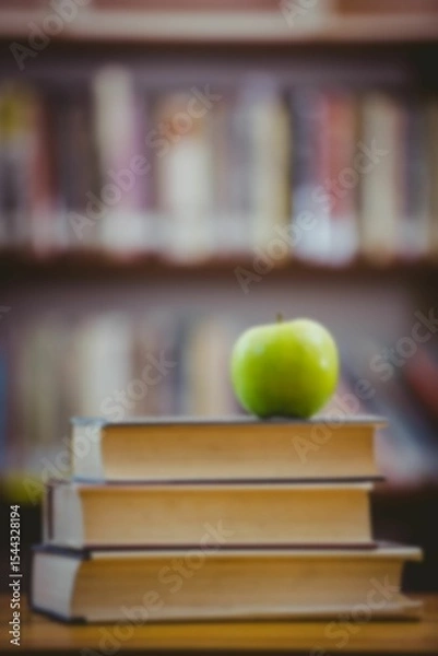 Obraz Green apple on stack of books