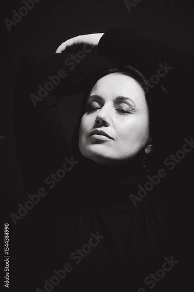 Obraz Portrait of a woman with dark hair, done in low key style.