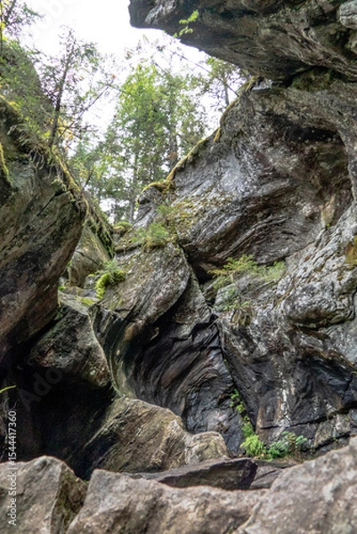 Fototapeta A close-up view of the split giant’s kettle at Pumpulikirkko, a striking geological rock formation in Rautavaara, Finland. Towering stone walls frame the rugged chasm, shaped by natural forces in time