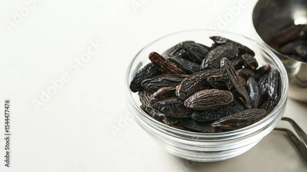 Fototapeta closeup pile of tonka bean in glasses bowl on white table background with copy space