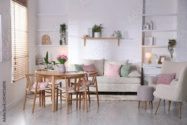 Fototapeta Stylish dining table with chairs and comfortable sofa in room. Interior design