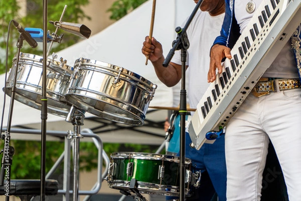 Fototapeta Summer music festival at the park with band playing drums and keytar on the stage