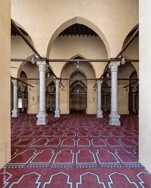 Fototapeta Al-Zahir Baybars Mosque, a testament to Egypt's profound Islamic heritage, is characterized by its towering columns, arched passages, and intricately decorated prayer carpet