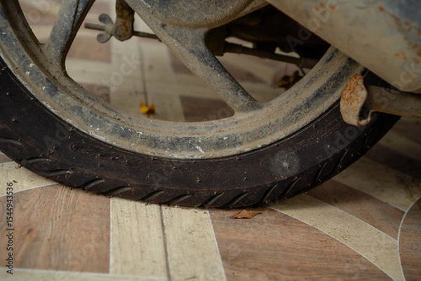 Fototapeta Flat Tire On A Motorcycle In An Urban Setting With Worn Flooring