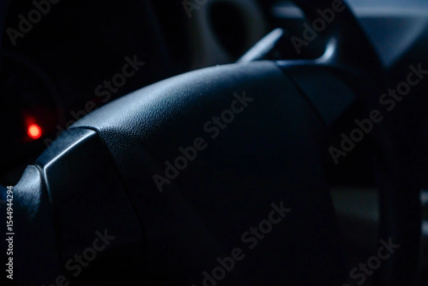 Fototapeta Close-up Of A Vehicle Steering Wheel With Soft Lighting And Moody Atmosphere