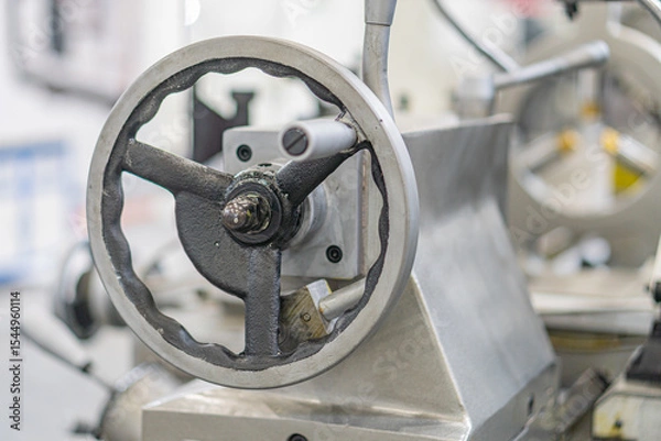 Fototapeta Industrial machine parts, gray and metallic tones, large gear or sprocket, flange, factory or workshop setting, mechanical structure, muted colors, no people, no text