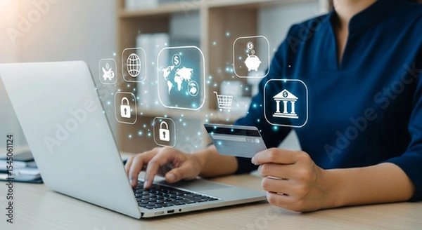 Fototapeta Woman using laptop for online banking with credit card and digital financial icons floating above it