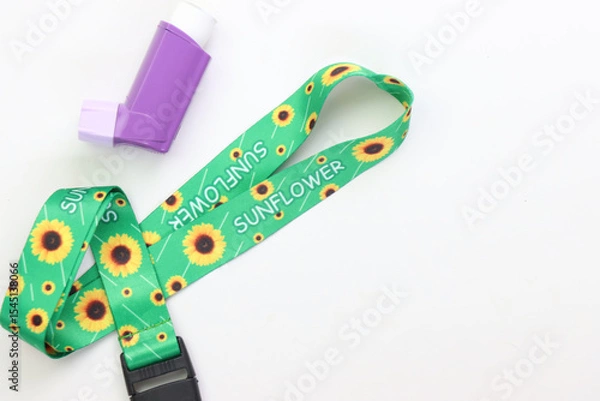 Fototapeta Hidden disability lanyard with a asthma device in a light background