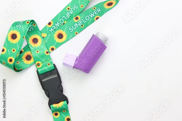 Fototapeta Hidden disability lanyard with a asthma device in a light background