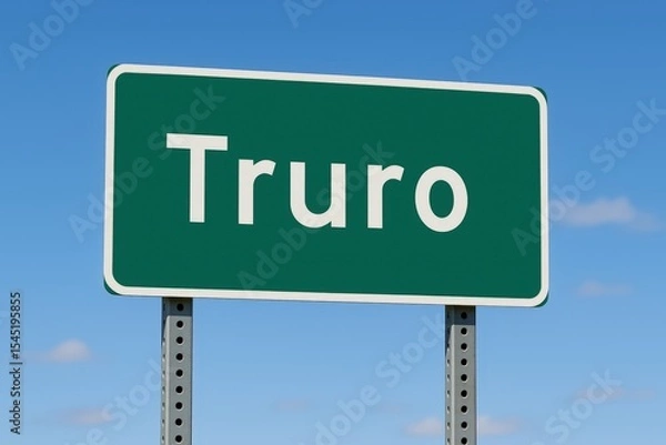 Fototapeta Truro town entry sign displayed on a green road sign with a bright blue sky in the background, suggesting travel.