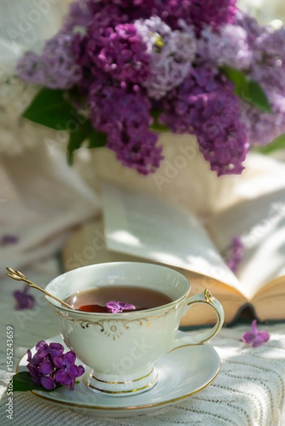 Obraz A bouquet of lilacs on the table and a cup of tea.