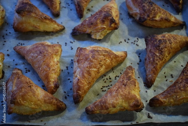 Fototapeta Flaky Triangular Pastries with Sesame Seeds