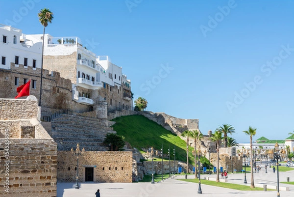 Fototapeta Scenic views of Tangier's seafront and old medina walls on a sunny day, showing a mix of coastal charm, public spaces, and historic Moroccan architecture