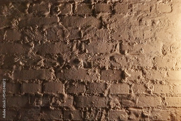 Fototapeta Illuminated brick wall in a dark cellar.