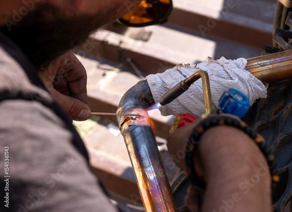 Obraz worker soldering copper pipes