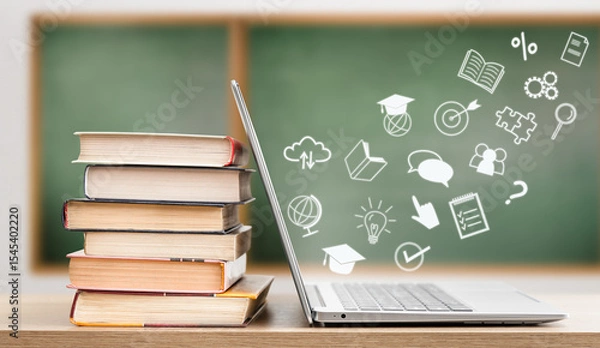 Fototapeta icons flying out of laptop, next to stack of books, on chalkboard background. e-learning concept
