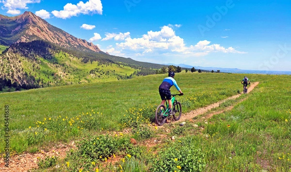 Fototapeta Mountain bikers on Boulder, Colorado's Springbrook Trail with the Flatirons in the background
