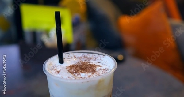 Obraz Female barista stirring frothy cappuccino, chocolate dust topping, relaxing near sunlit cafe window