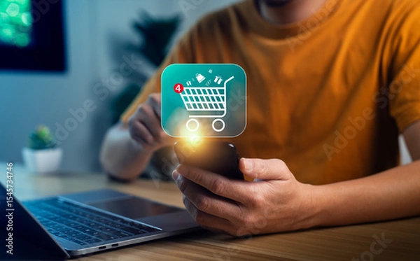 Obraz Close-up hand holding smartphone with glowing shopping cart icon and notification badge, symbolizing mobile shopping app, digital e-commerce, online retail, internet purchase, smart consumer behavior