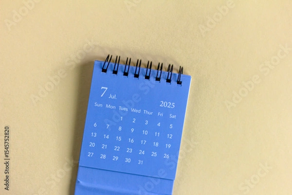 Fototapeta Hello, July 2025. Desktop calendar for planning on a beige background with copy space.