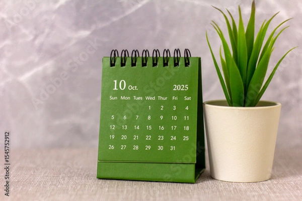 Fototapeta Desktop calendar for October 2025 on the desktop.