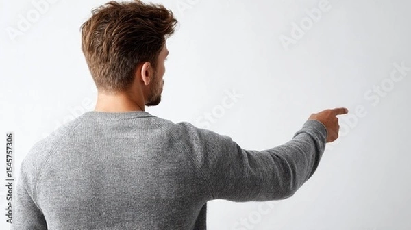 Fototapeta A man in a gray sweater pointing at something