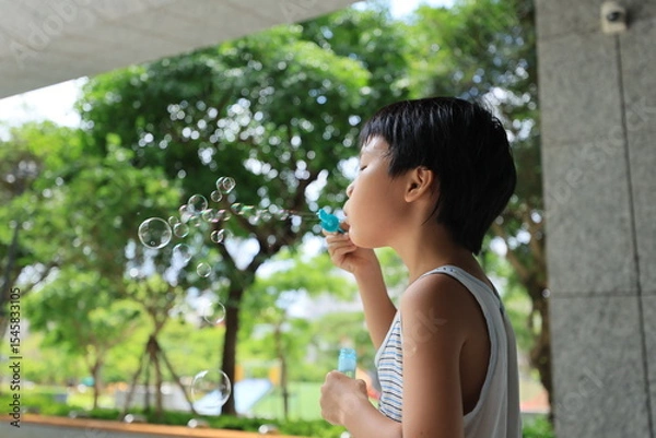 Fototapeta Boy blowing bubbles.