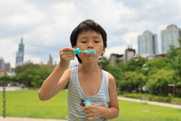Fototapeta Boy blowing bubbles.