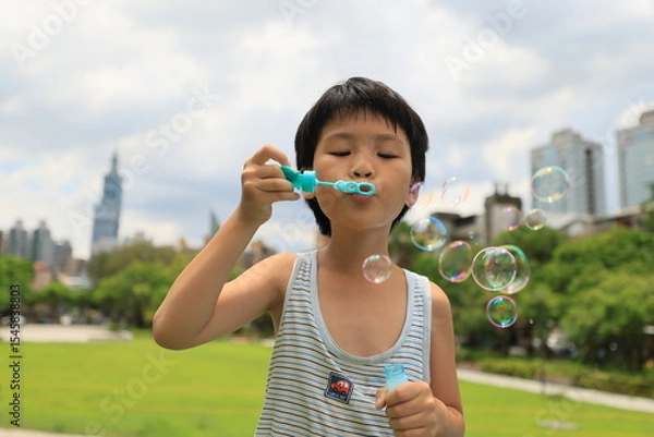 Fototapeta Boy blowing bubbles.
