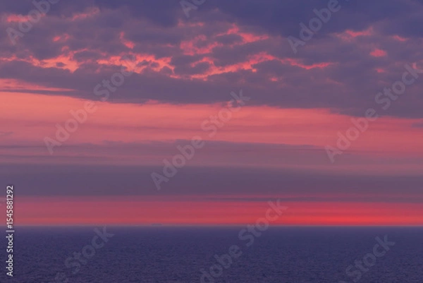 Fototapeta View from a cruise ship in the Norwegian Sea at sunset: the endless horizon glows with soft pink and blue tones. A tranquil ocean and sky background perfect for serene visuals.