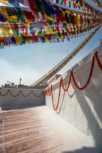 Obraz Boudhanath Stupa wall decorated with garlands of velvets (mala) and prayer flags above it. Kathmandu, Nepal