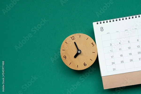 Fototapeta close up of calendar and clock on the green table background, planning for business meeting or travel planning concept