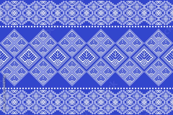 Fototapeta Traditional Praewa fabric pattern inspired by Thai textile culture, designed in geometric pixel art style. Features symmetrical diamond shapes and floral motifs in blue and white tones. Ideal for seam