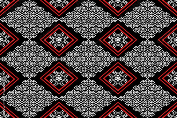 Fototapeta A bold and elegant seamless textile pattern inspired by traditional Southeast Asian weaving. This design features white geometric motifs with red diamond frames on a deep black background, creating a 