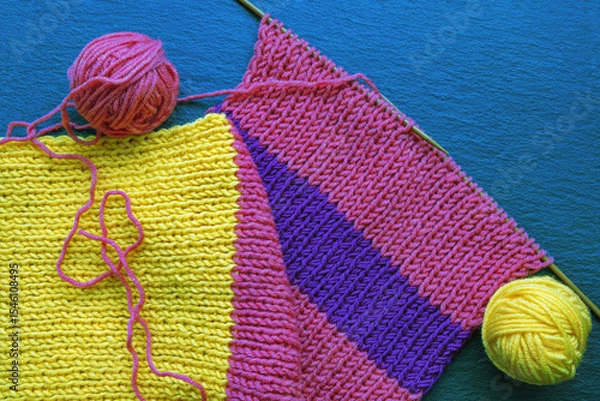 Fototapeta Knitting and hobbies concept.  Knitting colorful scarf. Balls of wool. Flat lay, copy space
