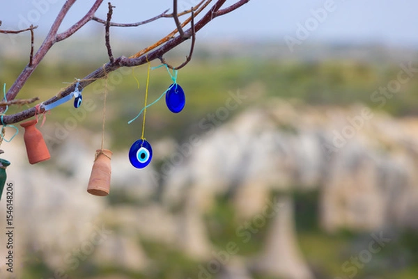 Fototapeta Blue Evil Eye pendants and small clay love pots in Wish tree against blurred background in Cappadocia, Turkey.