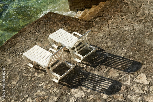 Obraz  Sonnenliegen an einer typischen Badestelle entlang der steinigen Küste von Porec an der kroatischen Adria 