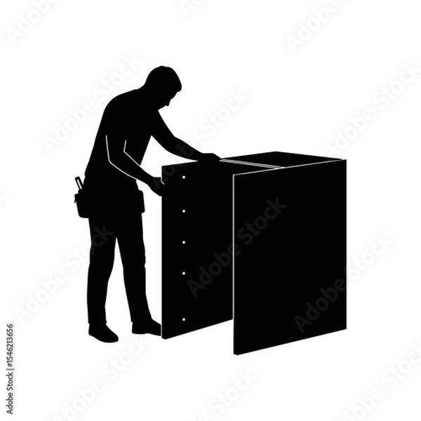 Fototapeta Man assembling furniture while standing beside a cabinet in workshop  