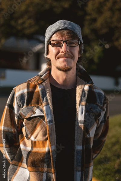 Fototapeta Happy Man in Plaid warm Shirt, Beanie and Glasses in Suburban Setting