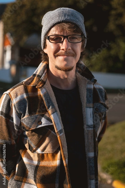 Fototapeta Happy Man in Plaid warm Shirt, Beanie and Glasses in Suburban Setting