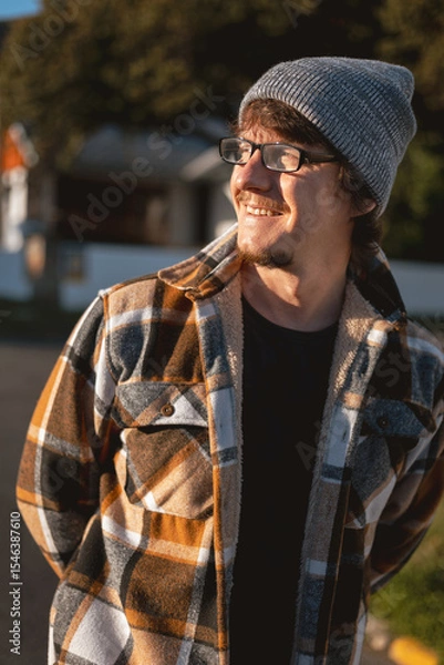 Fototapeta Happy Man in Plaid warm Shirt, Beanie and Glasses in Suburban Setting