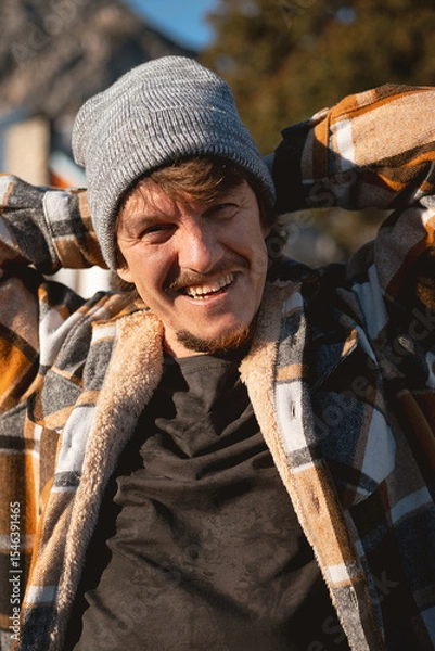 Fototapeta Happy Man in Plaid warm Shirt and Beanie in Suburban Setting