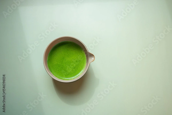 Obraz The Matcha green tea on a pastel green background, shot in still life style.