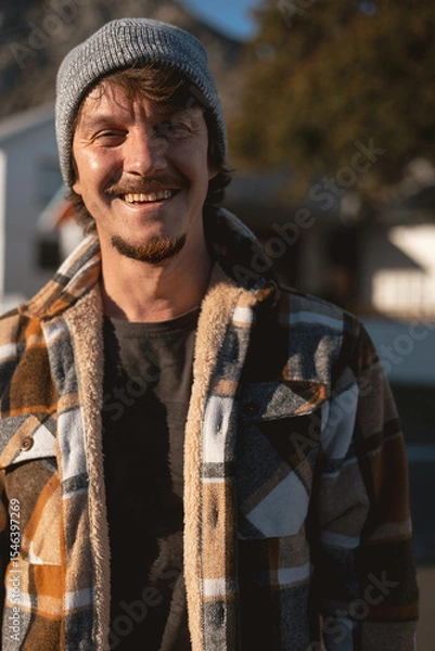 Fototapeta Happy Man in Plaid warm Shirt and Beanie in Suburban Setting
